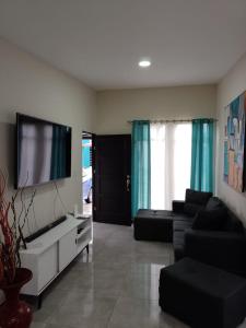 a living room with a couch and a flat screen tv at Condominio in Cartago