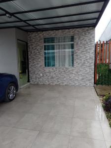 a garage with a car parked next to a brick wall at Condominio in Cartago