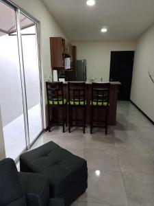 a living room with a couch and a kitchen at Condominio in Cartago