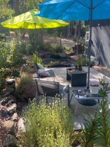 a patio with an umbrella and a table and chairs at Spa Suites at RAVEN in Hepburn Springs