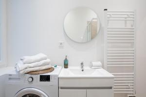 uma casa de banho branca com uma máquina de lavar roupa e um espelho. em Le Sweet Forville 2 - Palais des Festivals - Marché provençal - Plage - Clim - Au calme em Cannes