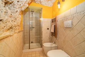 uma casa de banho com um WC, um chuveiro e um lavatório. em La Casa dell' Etrusco em Tarquinia