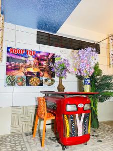 a red table with flowers and vases on a wall at MOONLIGHT HOMESTAY & HOSTEL in Jaipur