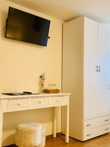 a room with a desk with a tv on the wall at Steinbock Bed & Breakfast in Fischen