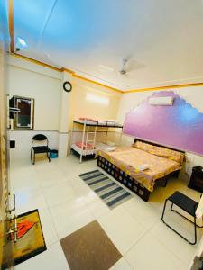 Habitación con cama, mesa y sillas. en MOONLIGHT HOMESTAY & HOSTEL, en Jaipur