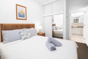 Un dormitorio blanco con una cama blanca y un baño. en Rainbow Shores Resort Getaway!, en Rainbow Beach 19 fotos más