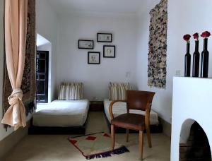 une chambre avec un lit, une chaise et une table dans l'établissement Riad Dar Dallah, à Marrakech