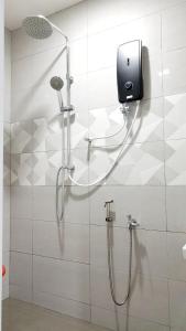 a shower in a bathroom with a phone on a wall at EA Homestay Lembah Bujang Merbok in Bedung