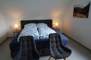 a bedroom with a blue bed with two side tables at Casa de Alpaca in Schmelz