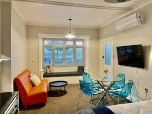 una sala de estar con una mesa y sillas en Beach Front Studio Napier, en Napier