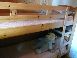 un orsacchiotto imbottito seduto su un letto a castello di Chalet Les Eterlous a Bonneval-sur-Arc