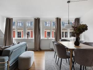 een woonkamer met een tafel en stoelen en een bank bij Sanders Leaves - Precious Two-Bedroom Penthouse In Downtown Copenhagen in Kopenhagen