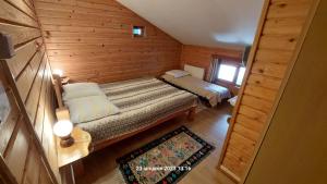 mały pokój z 2 łóżkami w drewnianym domku w obiekcie Pensiunea DANA w mieście Predeal