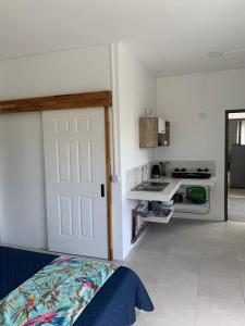 1 dormitorio con cama, puerta blanca y cocina en Cosy Corner en La Gaulette