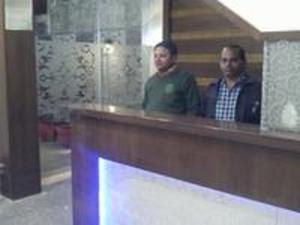 a man and a woman standing behind a counter at Abhiraj Guest House in Mathura