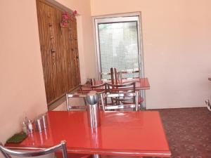 a room with red tables and chairs and a window at Abhiraj Guest House in Mathura