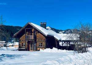 Cabaña de madera con nieve en el techo en Haus Liesenfeld, en Gosau