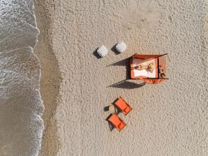 an overhead view of a beach with a tent and two chairs at Aquila Rithymna Beach in Adelianos Kampos