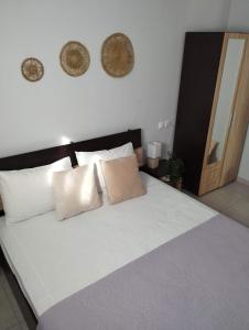 a bedroom with a large white bed with pillows at MAGDA APARTMENTS in Nea Roda