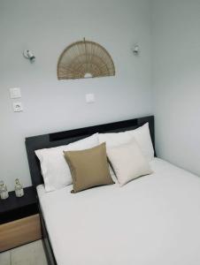 a white bed with four pillows on top of it at MAGDA APARTMENTS in Nea Roda