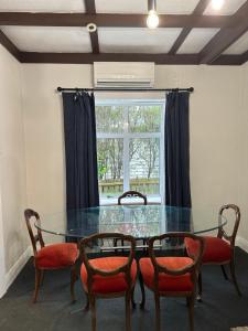 a dining room with a glass table and chairs at Rotorua Holiday Villa in Rotorua