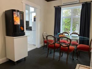 a dining room with a table and a tv on a stand at Rotorua Holiday Villa in Rotorua