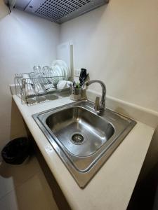 a stainless steel sink in a kitchen with dishes at Grand Riviera Suits in Manila