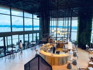 un vestíbulo con bar, mesas y ventanas en Sea View Sandy homestay Citadines Marina Ha Long en Ha Long