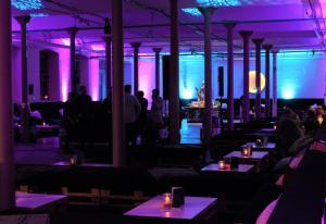 a restaurant with purple lights in a room with tables at Kulturfabrik Schönbach in Schönbach