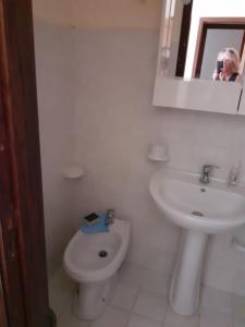 un hombre tomando una foto de un baño con aseo y lavabo en Idea Vacanze Musso - Struttura 1, en Ravanusa