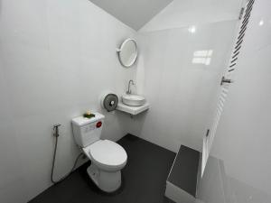 a white bathroom with a toilet and a sink at Koh Jum Paradise Resort in Ko Jum