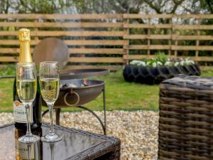 two glasses of champagne on a table with a grill at Bramley Cottage in North Weald