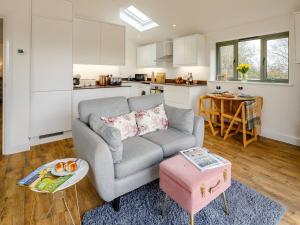 a living room with a couch and a table at Bramley Cottage in North Weald