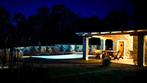 Dobrinj的住宿－Villa Rustica，后院,在晚上设有游泳池和凉亭