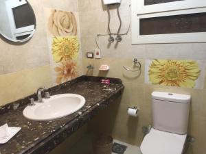 baño con lavabo y aseo con flores en la pared en Residence familiale à la meilleure place en El Cairo