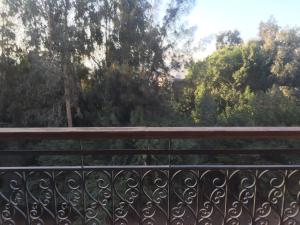 un banco en un balcón con árboles en el fondo en Residence familiale à la meilleure place en El Cairo