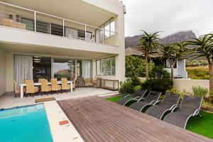 a villa with a swimming pool and a dining area at Cape Blue in Cape Town