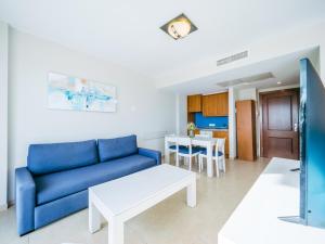 een woonkamer met een blauwe bank en een tafel bij Prope Mare Apartamentos in Cala Millor