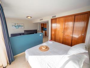 Prope Mare Apartamentos في كالا مييور: غرفة نوم مع سرير مع قبعة عليه