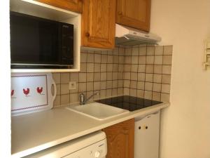 a kitchen with a sink and a microwave at Appartement avec terrasse magnifique vue montagne in Saint-François-Longchamp +47 photos