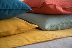 een stapel kleurrijke kussens op een bed bij La Laiterie du Gontey in Cervières