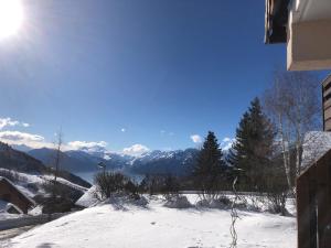 a view of a snowy mountain with the sun in the sky at Appartement avec terrasse magnifique vue montagne in Saint-François-Longchamp