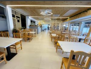 a restaurant with white tables and wooden chairs at Hotel El Molino in Ciudad Real