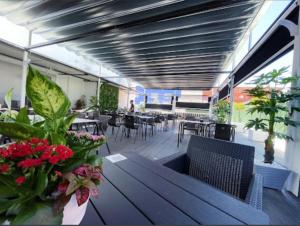 a dining room with tables and chairs and flowers at Hotel El Molino in Ciudad Real