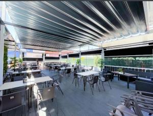 a restaurant with tables and chairs and a roof at Hotel El Molino in Ciudad Real