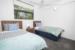 a bedroom with two beds and a window at Emohruo Rainbow Shores - 3 Br Resort Apartment in Rainbow Beach +38 photos