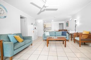 una sala de estar con 2 sofás azules y una mesa. en Emohruo Rainbow Shores - 3 Br Resort Apartment en Rainbow Beach