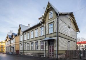 a large wooden building with a red door at AirHome - Owl's Nest 2 in Tallinn