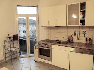 eine Küche mit weißen Schränken, einem Waschbecken und einem Fenster in der Unterkunft ApartInn in Mannheim