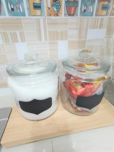 two jars of food sitting on a cutting board at Apartment in Ladang Tok Pelam - Hana Home by the Sea in Kuala Terengganu